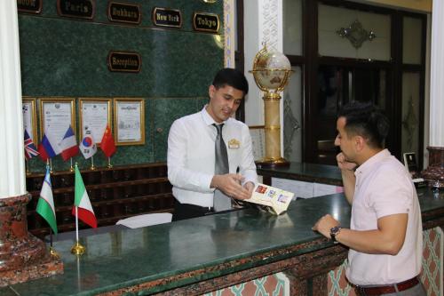 two men standing at a counter in a bar at Zargaron Plaza in Bukhara