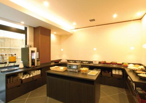 a restaurant kitchen with a counter with food on it at AB Hotel Kyoto Shijo Horikawa in Kyoto