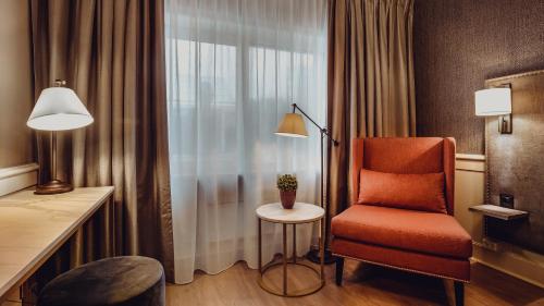 a hotel room with a chair and a window at Home Hotel Grand Bodø in Bodø
