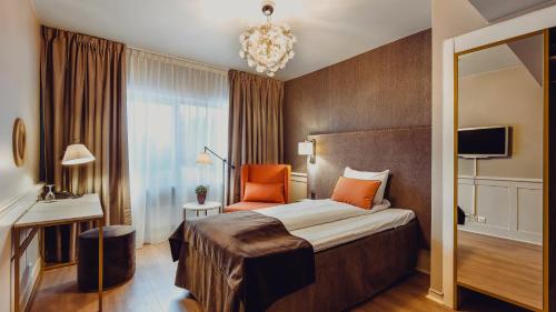 a hotel room with a bed and a chandelier at Home Hotel Grand Bodø in Bodø