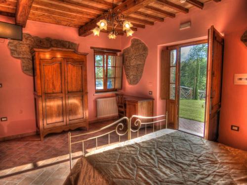 a bedroom with orange walls and a bed and a window at Agriturismo Podere Del Lepre in San Quirico