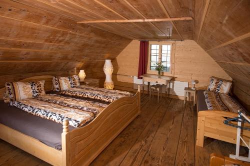 - une chambre avec 2 lits dans une cabane en rondins dans l'établissement Bed and Breakfast Huobschür, à Hellbühl