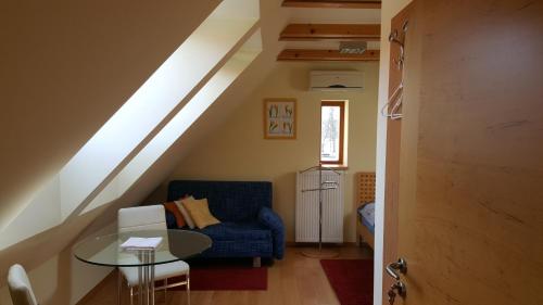 a living room with a blue chair and a glass table at Jihoceska Pohoda in Třeboň
