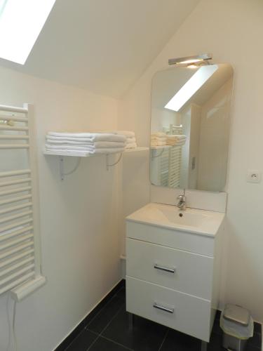 une salle de bain blanche avec un lavabo et un miroir dans l'établissement OSCAR's HOME, à Soppe-le-Bas