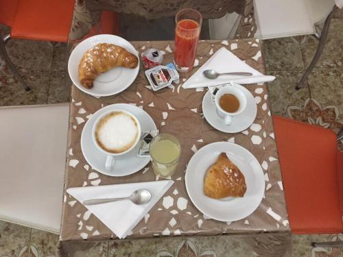 a table with two cups of coffee and croissants at Hotel des Artistes in Naples