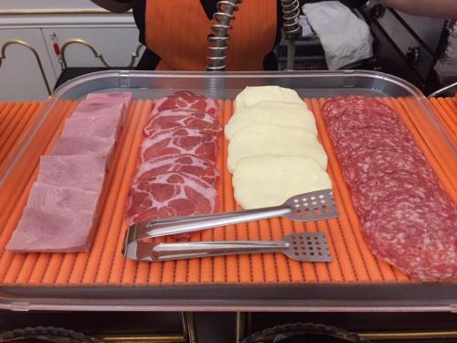a tray of different types of meats and cheese at Hotel des Artistes in Naples