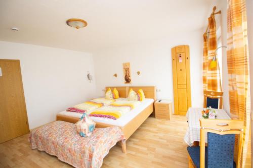 sypialnia z 2 łóżkami i stołem w obiekcie Pension Eichschmid / Röll´n Biergarten w mieście Bad Gögging
