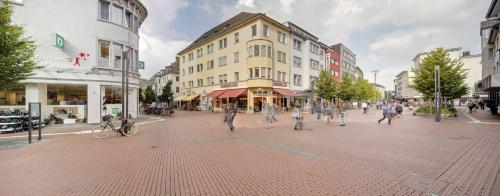 a group of people walking down a city street at Best Western Plus Hotel Steinsgarten in Gießen