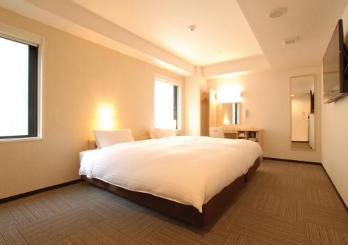 京都的住宿－京都四條堀川 AB 飯店，卧室设有一张白色大床和一扇窗户。