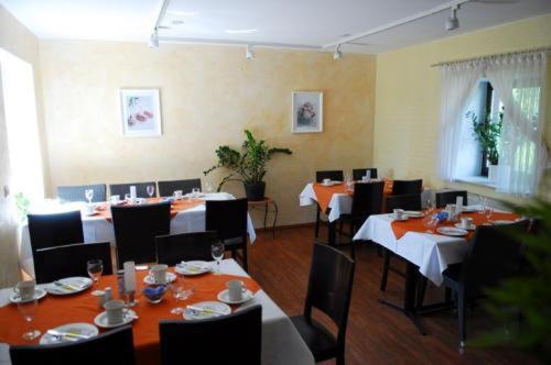 a dining room with tables and chairs in a restaurant at Adam Hotel in Giesen