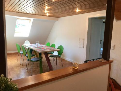 a dining room with a table and green chairs at Ferienwohnung Seerose Bad Wildbad i. Schwarzwald in Bad Wildbad