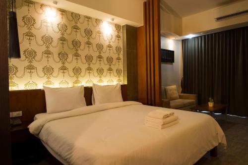 a hotel room with a bed with towels on it at Inn Residence Serviced Suites - SHA Extra Plus in Jomtien Beach