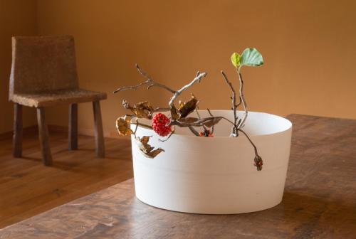 a white vase with a plant in it on a table at Arima Onsen Takayamaso Hanano in Kobe