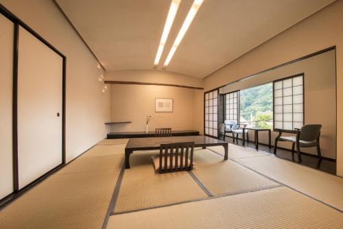 a room with a table and chairs in a room at Arima Onsen Takayamaso Hanano in Kobe
