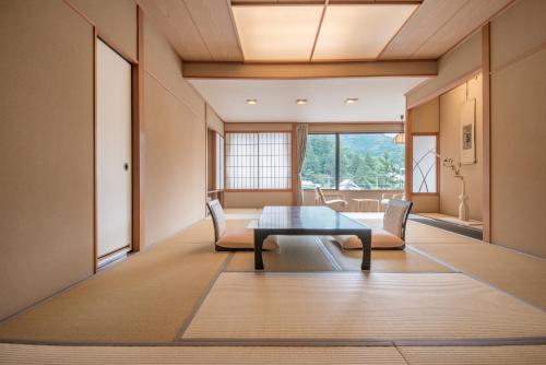 sala de estar con mesa y sillas en Arima Onsen Takayamaso Hanano en Kobe