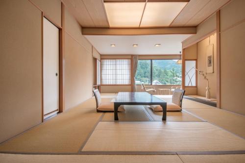 a living room with a table and chairs at Arima Onsen Takayamaso Hanano in Kobe
