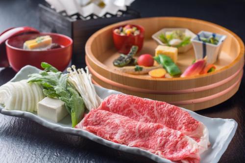 a plate of food with meat and vegetables on a table at Arima Onsen Takayamaso Hanano in Kobe