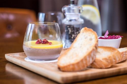 a glass of orange juice and bread on a cutting board at Kilmurry Lodge Hotel in Limerick