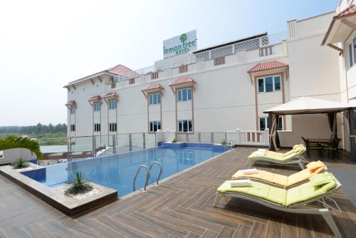 a hotel with a swimming pool in front of a building at Lemon Tree Hotel Coimbatore in Coimbatore