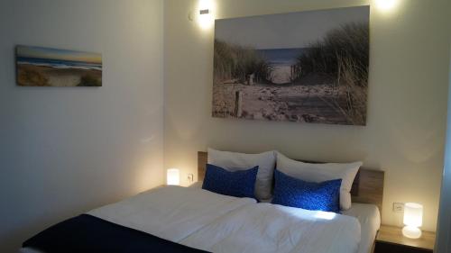 um quarto com uma cama com duas fotografias na parede em Schönes Ferienhaus direkt am Meer em Stomorska
