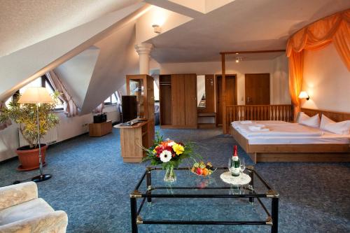 a hotel room with a bed and a table with flowers at Hotel Waldesruh in Lengefeld