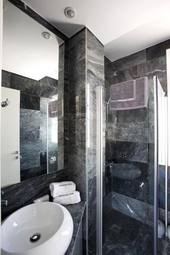 a bathroom with a sink and a shower at Paradise Cove Luxurious Beach Villas in Paphos