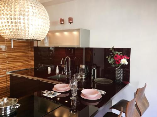 a kitchen with a dining table with plates and glasses at ComeWa Apartments in Warsaw