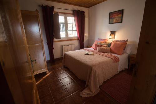 un dormitorio con una cama y una ventana en Turismo Rural O Xastre de Anos, en Cabana de Bergantiños