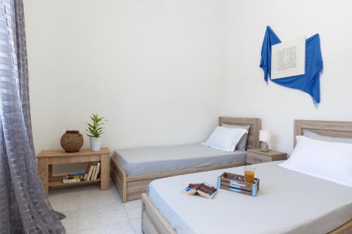 a room with two beds and a table with books at Sweet Home Kremasti in Kremasti