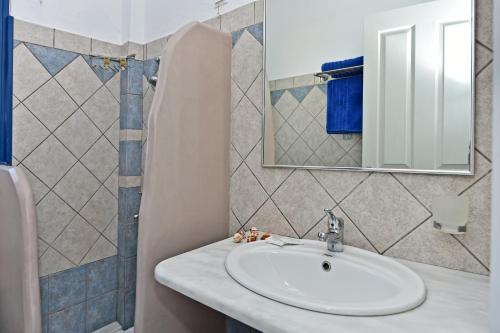 uma casa de banho com um lavatório e um espelho em Akti Aegeou em Ayios Sostis