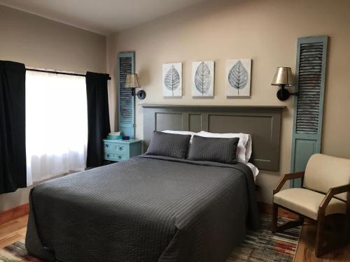a bedroom with a bed and a chair at Hocking Hills Inn in Logan