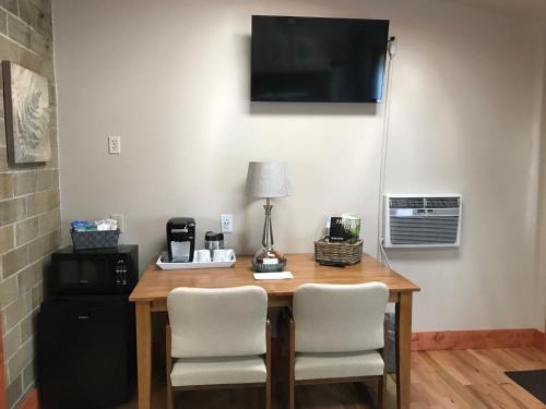 a table with two chairs and a television on a wall at Hocking Hills Inn in Logan