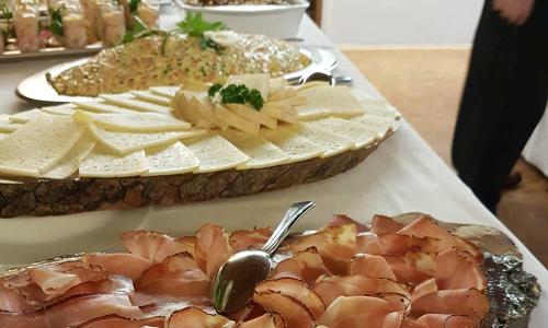a table topped with meats and cheese on a table at Hotel Rose in Villabassa