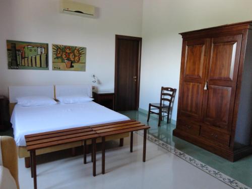 a bedroom with a bed and a wooden cabinet at La Taverna in Floridia