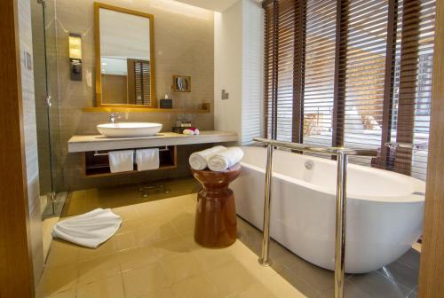 a bathroom with a bath tub and a sink at Pullman Luang Prabang in Luang Prabang