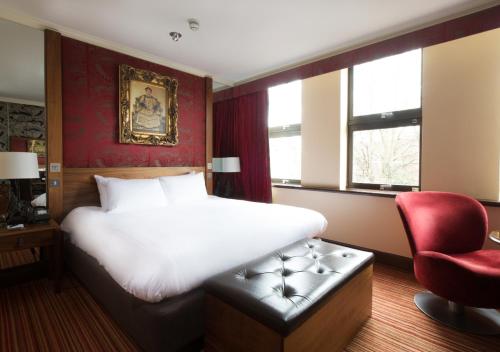a bedroom with a large bed and a red wall at The Queen at Chester Hotel, BW Premier Collection in Chester