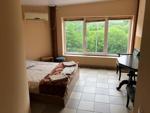 a bedroom with a bed and a desk and a window at Мотель "Євро" in Chernivtsi