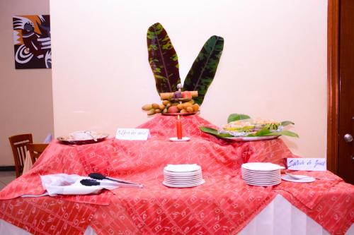 a table with plates and a bird on top of it at Beausejour Hotel in Kigali
