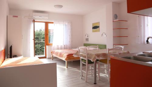 a kitchen and dining room with a table and chairs at Apartments Laura in Pinezici