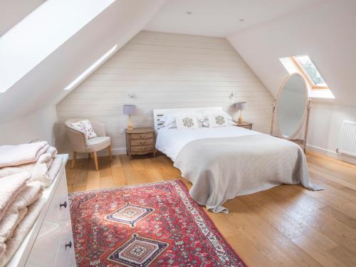 1 dormitorio con 1 cama, 1 silla y 1 alfombra en Shakespeare Cottage en Lincoln