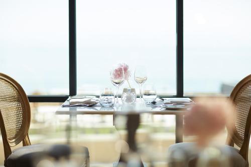 a table with wine glasses on it in front of a window at Nido, Mar-Bella Collection in Agios Ioannis Peristeron
