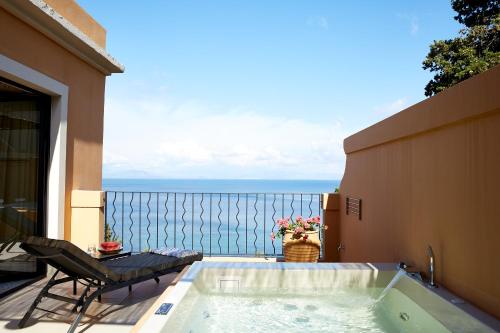 a hot tub on a balcony with a view of the ocean at Nido, Mar-Bella Collection in Agios Ioannis Peristeron