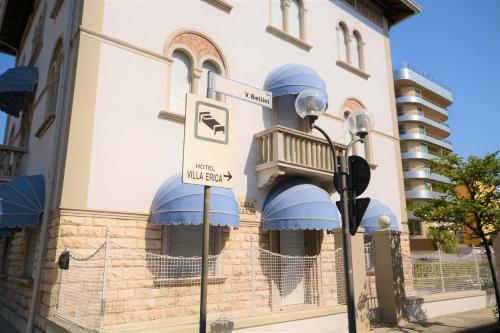 a building with blue awnings and a balcony at Les 7 Suites Erica in Grado