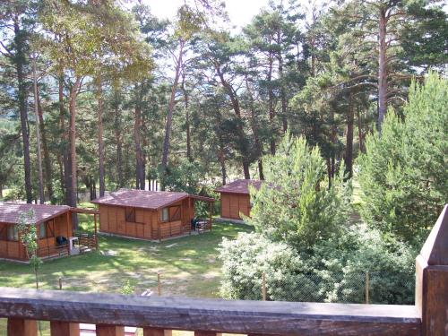 a group of cottages in a yard with trees at Camping Cobijo in Vinuesa