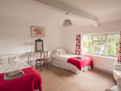 a bedroom with two beds and a desk and a window at The Brewhouse in Doddington
