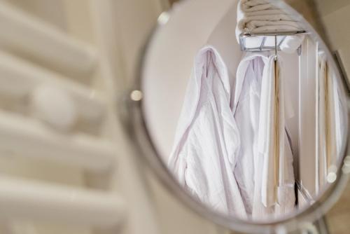 a mirror with white towels hanging on a rack at Il Podere di Marfisa in Farnese