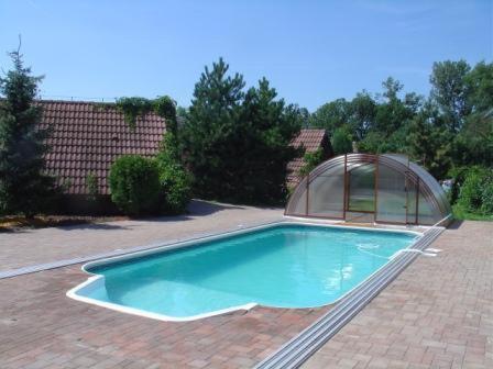 uma piscina com um gazebo num quintal em Motel Charlie em Kovač