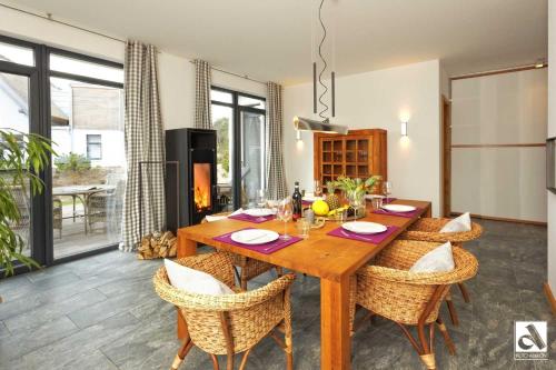 comedor con mesa de madera y sillas en Kapitaensweg 15 en Ostseebad Karlshagen