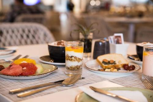 a table with plates of food and glasses of milk at Tete Ferry Sun in Vila-de-Santiago-Maior