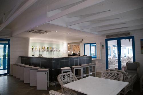 a restaurant with a bar with tables and chairs at Tete Ferry Sun in Vila-de-Santiago-Maior